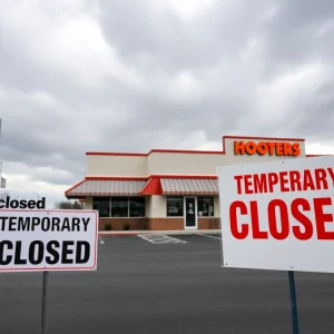 A Hooters restaurant closed with a sign on the door
