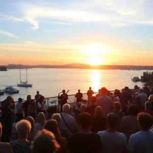 Submit Obituary Sea of people enjoying a jazz concert by the river during sunset.